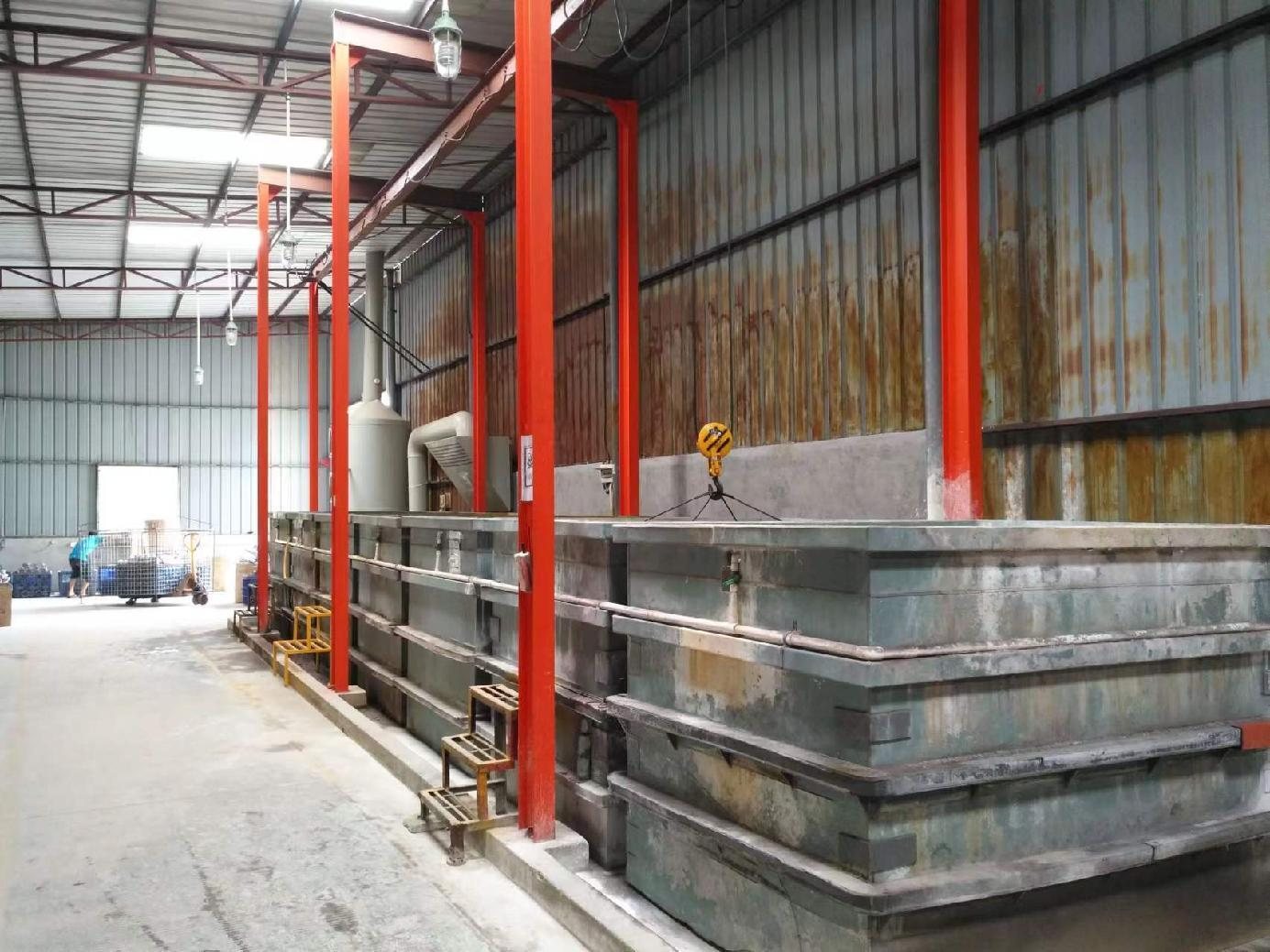 Rows of dip tanks in the rust-removal and coating bay